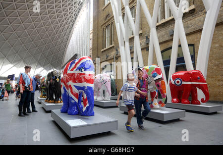 USAGE ÉDITORIAL SEULS les membres du public regardent les éléphants exposés lors du lancement de l'Elephant Parade National Tour présenté par intu, à la gare de Kings Cross à Londres. Banque D'Images