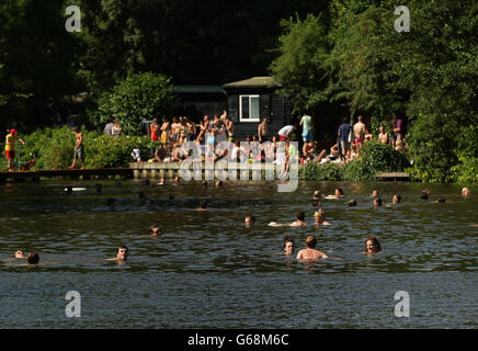 Nageurs et baigneurs de soleil profitant du temps chaud dans les bassins mixtes de Hampstead Heath, dans le nord de Londres. Banque D'Images