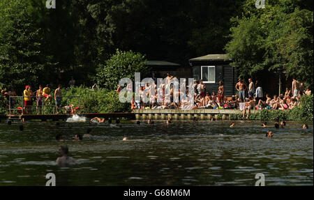 Nageurs et baigneurs de soleil profitant du temps chaud dans les bassins mixtes de Hampstead Heath, dans le nord de Londres. Banque D'Images