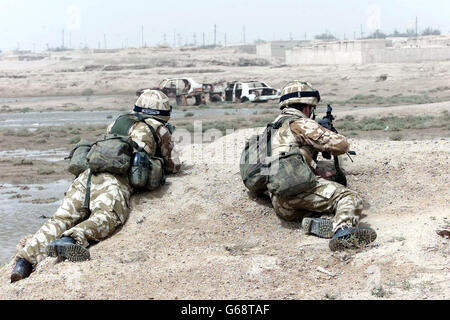 Des membres de l'armée britannique apportent des secours humanitaires au peuple de l'Imam Anas, une colonie située au sud de la ville de Bassora. Les troupes étaient préoccupées par une attaque de sniper à l'intérieur de l'établissement. Banque D'Images