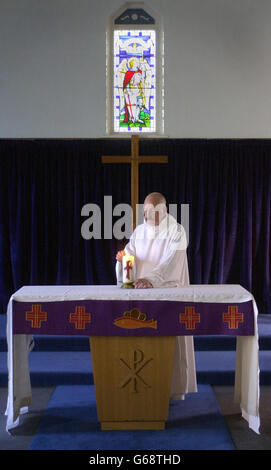 Le révérend William Mounsey, aumônier anglican de la RAF Leuchers, Fife, allume une bougie pour la paix, dans l'église St Paul et St Michael's à la base. Banque D'Images