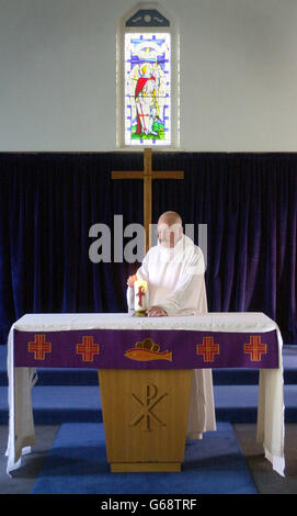 Le révérend William Mounsey, aumônier anglican de la RAF Leuchers, Leuchers, Fife. Il est photographié éclairant une bougie pour la paix dans l'église St Paul et St Michaels à la base . Banque D'Images