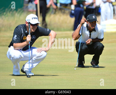 Le Tiger Woods des États-Unis et le Louis Oosthuizen de l'Afrique du Sud (à gauche) font la queue sur le premier green au cours du premier jour du Championnat Open 2013 au Club de golf de Muirfield, East Lothian. Banque D'Images