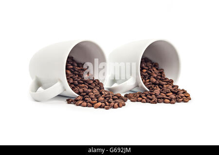 Deux tasses de café blanc et renversé du café-beans isolated on white Banque D'Images