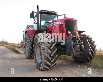 Sale énorme tracteur agricole rouge couvert de craie blanche du sol North Wessex Downs stationnée sur le promeneur à pied sur Walbury Hill. Banque D'Images