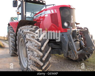 Sale énorme tracteur agricole rouge couvert de craie blanche du sol North Wessex Downs stationnée sur le promeneur à pied sur Walbury Hill. Banque D'Images