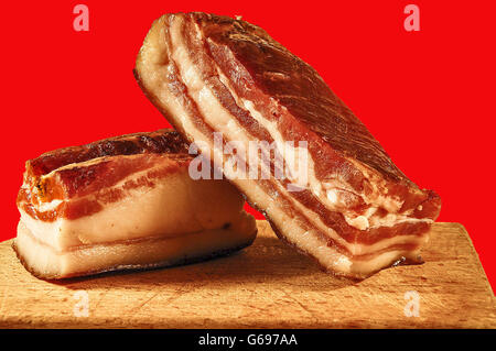 Deux morceaux de viande, lard fumé maison sur une planche à découper de cuisine. Banque D'Images