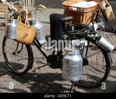 Bidons de lait en aluminium transportés sur de vieux vélo le laitier Banque D'Images