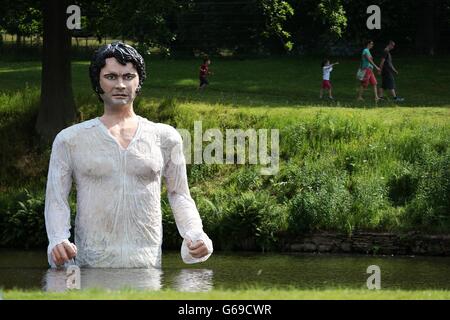 Les gens apprécient le temps chaud en face d'une statue de Jane Austen héros romantique MR Darcy émergeant d'un lac dans le Parc de Lyme, Manchester. APPUYEZ SUR ASSOCIATION photo. Date de la photo: Samedi 20 juillet 2013. Le crédit photo devrait se lire comme suit : Lynne Cameron/PA Wire Banque D'Images