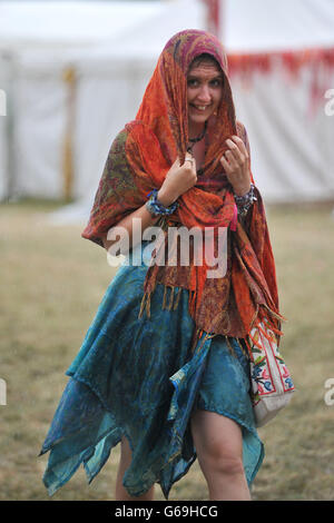 Un gardien de festival se tient à l'abri de la pluie pendant le festival Womad 2013, qui s'est tenu à Charlton Park, Wiltshire. Banque D'Images