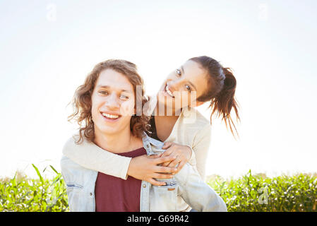 Man giving girlfriend piggyback ride Banque D'Images