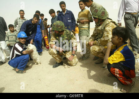 Le capitaine Dai Jones (à gauche) du Queen's Lancashire Regiment et le caporal Mark Pearsall de la Brigade d'assaut aérienne de 16 rencontrent des habitants de la ville de Romala, dans le sud de l'Irak. Banque D'Images