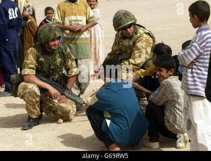 Le capitaine Dai Jones (à gauche) du Queen's Lancashire Regiment et le caporal Mark Pearsall de la Brigade d'assaut aérienne de 16 rencontrent des habitants de la ville de Romala, dans le sud de l'Irak.15/08/03 : le capitaine Jones, 29 ans, du 1er Régiment du Lancashire de la Reine, est décédé hier lorsque l'ambulance dans laquelle il voyageait a été visée par une attaque à la bombe près de Bassora, dans le sud de l'Irak. Banque D'Images