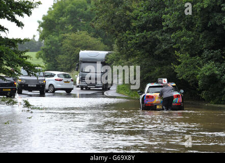 Moniteur de conduite, qui a fait son élève des lieux d'échange avec lui, d'appuyer sur son véhicule après qu'il est resté coincé dans une route inondée à Writtle, Essex, comme les inondations et les pluies torrentielles ont inondé certaines parties de Londres et le sud-est dans les premières heures du jour pour un référendum, avec la London Fire Brigade inondés d'une journée d'appels en seulement 90 minutes. Banque D'Images