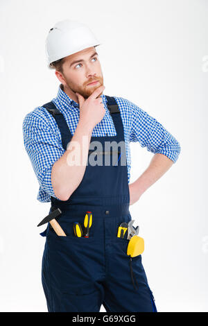 Pensive beau jeune builder et pensée looking up Banque D'Images