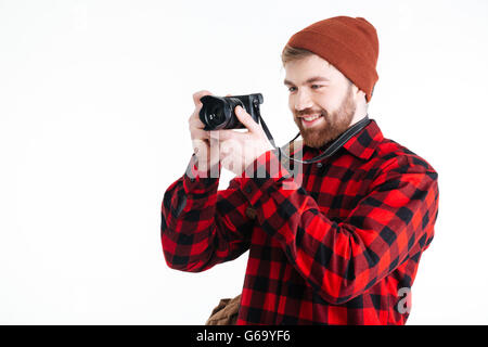 Hipster jeune homme prend une photo avec un appareil photo vintage isolé sur fond blanc Banque D'Images