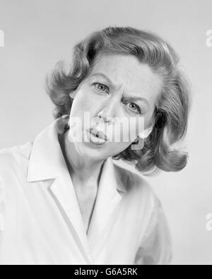 Années 1950 Années 1960 PORTRAIT FEMME AVEC L'EXPRESSION DU VISAGE DE QUESTIONNEMENT EN COLÈRE Banque D'Images