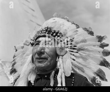 1960 PORTRAIT CHEF SIOUX STONEY GULL NATIVE AMERICAN homme portant une coiffe À PLUMES MORLEY RESERVATION ALBERTA CANADA Banque D'Images