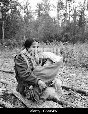 1970 NATIVE AMERICAN WOMAN MOTHER HOLDING BABY PAPOOSE EN ISRAEL'S LANDING Rivière Yukon DAWSON CANADA Banque D'Images