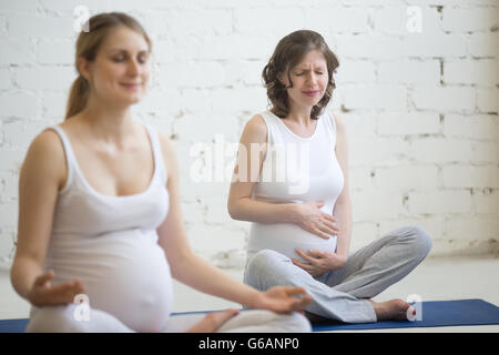 Personne enceinte ventre sentiment douleur au cours de yoga ou de remise en forme à l'intérieur. Young pregnant woman holding sa sensation de malaise à l'estomac Banque D'Images
