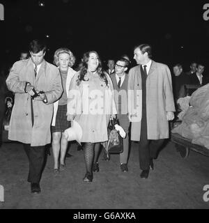 Cass Elliot (au centre), chanteuse avec le groupe pop américain The Mamas et The Papas, à son arrivée à la gare de Waterloo à Londres.Elle a été escortée de Southampton par deux détectives et emmenée au poste de police de Kensington, où elle a été accusée de voler des articles d'un hôtel de Londres. Banque D'Images