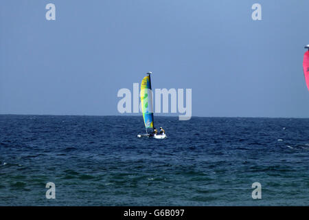 Petit bateau à voile avec de belles voiles colorés...sur bleu profond de la mer des Caraïbes sur une chaude journée ensoleillée avec ciel bleu profond Banque D'Images