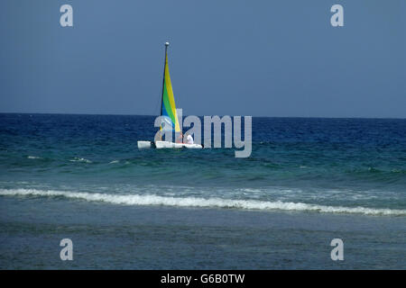 Petit bateau à voile avec de belles voiles colorés...sur bleu profond de la mer des Caraïbes sur une chaude journée ensoleillée avec ciel bleu profond Banque D'Images