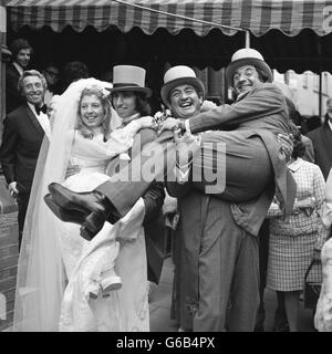 Mike Winters est levé par le frère Bernie, comme la mariée Beverley Wise - leur nièce - est levé par le marié Lawrence Swycher. Ils se sont mariés à la synagogue West End à St Petersburgh place, Londres. Banque D'Images