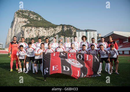 Gibraltar - 24 juin 2016 - en photo l'équipe de Gibraltar 2015-2016 Champions League FC Imps Rouge Lincoln qui se rendront à l'Estonie ce week-end pour jouer contre Flora Tallinn (EST) dans le premier tour premier match de qualification de la jambe de la Ligue des Champions le mardi 28 juin 2016. En photo avec la dernière squad au Victoria Stadium avec le Rocher de Gibraltar dans l'arrière-plan.Lincoln Imps rouges portent leur bande neuve après la signature d'un nouveau promoteur. Crédit : Stephen Ignacio/Alamy Live News Banque D'Images