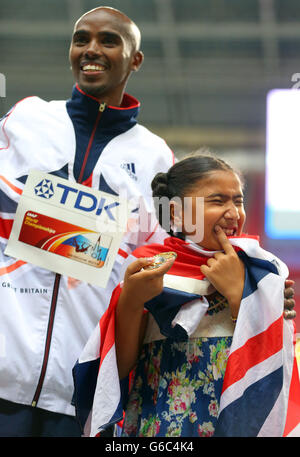 Le Mo Farah de Grande-Bretagne pose avec sa fille Rihanna après avoir gagné les hommes de 5000 mètres pendant le septième jour des Championnats du monde d'athlétisme de l'IAAF 2013 au stade Luzhniki à Moscou, en Russie. Banque D'Images