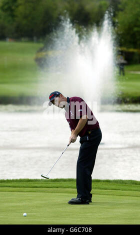 Padraig Harrington plonge son putt sur le 9e vert lors de son premier tour dans l'Open international de Benson & Hedges au Beffroi. Banque D'Images