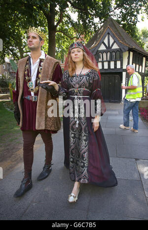 Un passant regarde les acteurs Kieran Tolan vêtus comme le roi Edward IV et JO Cummins habillé comme la reine blanche à Soho Square, Londres pour la sortie du drame de la BBC la reine blanche qui est maintenant disponible sur DVD. Banque D'Images