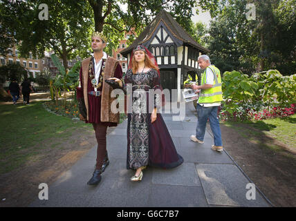 Un passant regarde les acteurs Kieran Tolan vêtus comme le roi Edward IV et JO Cummins habillé comme la reine blanche à Soho Square, Londres pour la sortie du drame de la BBC la reine blanche qui est maintenant disponible sur DVD. Banque D'Images