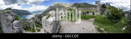Panorama 360° de la baie de Kotor tiré de la forteresse de St John montrant le fort, la baie et les murs bleu ciel nuageux. Banque D'Images