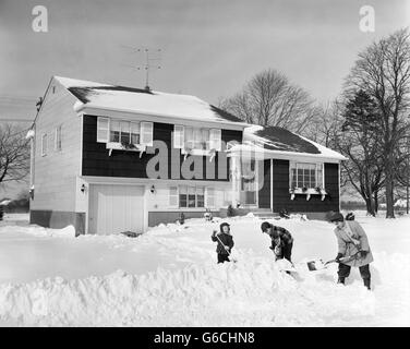 1950 Mère & FILS 2 EN FACE DE LA MAISON de pelleter la neige profonde de trottoir et l'allée Banque D'Images