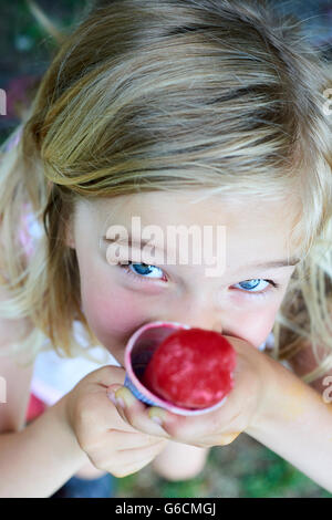 Belle petite fille blonde mange de la glace en été Banque D'Images