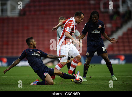 Charlie Adam de Stoke City a été attaqué par Ashley Hemmings de Walsall lors de la coupe Capital One, deuxième tour de match au stade Britannia, Stoke. Banque D'Images