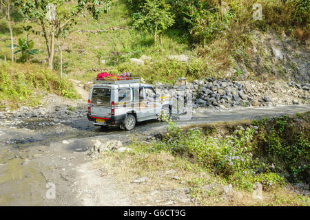 Un Sumo Tata taxi prend sur une mauvaise période de marécageux, route boueuse en route vers Pelling au Sikkim de Darjeeling, West Bengal, India Banque D'Images