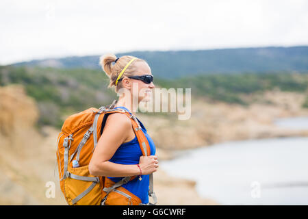 Sur le sentier de randonnée Femme avec sac à dos dans une station sur l'île. Loisirs et mode de vie sain à l'extérieur en été, les montagnes. Banque D'Images