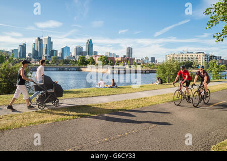 Les bicyclettes, reposant sur l'herbe et en poussant un landau sur le chemin du Canal de Lachine à Montréal Banque D'Images