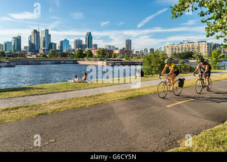 Les gens la bicyclette sur la piste cyclable du Canal de Lachine à Montréal, avec en arrière-plan. Banque D'Images