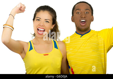 Charmant couple interracial portant des maillots de football jaune joyeusement à acclamer, blanc fond studio Banque D'Images