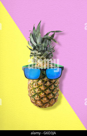 Bon été, fun idée concept fruits ananas portant des lunettes de soleil style hippie sur fond coloré. Banque D'Images