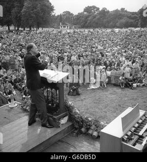 L'évangéliste américain DR.BILLY GRAHAM tisse des motifs avec ses mains lorsqu'il prêche à une foule de milliers de personnes lors d'un rallye en plein air à Victoria Park, Londres, dans le cadre de sa Croisade du Grand Londres. Banque D'Images