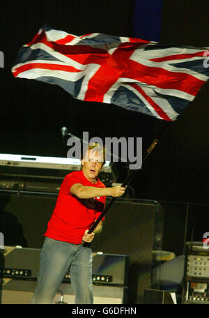 Sir Paul McCartney brandit un drapeau de l'Union à la fin de son concert à Kings Dock. 30,000 fans de McCartney sont descendus à Liverpool pour le concert final de l'ex-tournée mondiale des Beatles, que Sir Paul a surnommé son retour à la maison. * les portes ont ouvert à 17h30 mais des centaines de fans ont mis en file d'attente pendant des heures à l'avance pour sécuriser les places debout à l'avant de l'arène en plein air construite sur le but. Banque D'Images