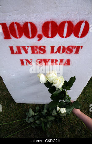 Un volontaire d'Oxfam s'agenouille devant des rangées de pierres tombales blanches symbolisant certaines des 100,000 vies perdues en Syrie, dans le centre-ville de Belfast, alors qu'Oxfam Irlande a appelé aujourd'hui les dirigeants mondiaux du G20 de cette semaine à Saint-Pétersbourg à intensifier leurs efforts pour un Solution politique pour mettre fin au bain de sang et aux souffrances du peuple syrien. Banque D'Images