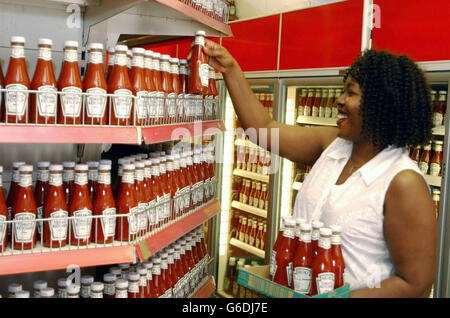 Le commerçant Tammy Omoniabipi dans son magasin d'alimentation Heinz Tomato Ketchup seulement à Kilburn, Londres. Tammy et sa sœur Patsy ont décidé de remplir leur boutique avec 9,432 bouteilles de ketchup après avoir lu dans leur journal local que Kilburn est la capitale de Ketchup au Royaume-Uni. Le ménage moyen de Kilburn obtient 4 400 g de ketchup par an, comparativement à la moyenne nationale de 3 300 g. Banque D'Images