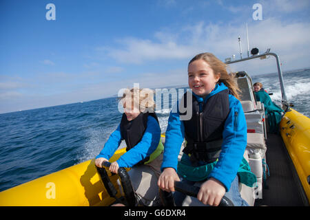 Deux enfants aimant le plaisir de la balade avec le capitaine Russell Moore de Xplore, au large des côtes de l'océan d'origine de San Diego-rafting pourvoyeur. La Californie. Banque D'Images