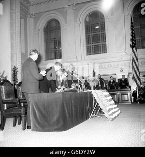 LE PRÉSIDENT AMÉRICAIN JOHN F. KENNEDY, est applaudi lorsqu'il signe le livre du visiteur à l'hôtel de ville, où il a reçu la liberté de la ville de Cork lors de sa visite de trois jours en Irlande. Avec lui, le maire Lord, SEAN CASEY, est en robes de chambre et dans la chaîne de bureau. Banque D'Images