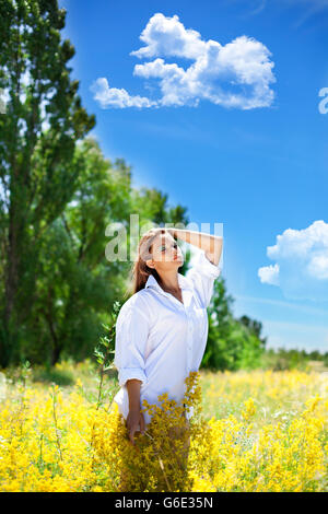 La jeune fille est titulaire d'un bouquet de fleurs sauvages dans la main. Banque D'Images